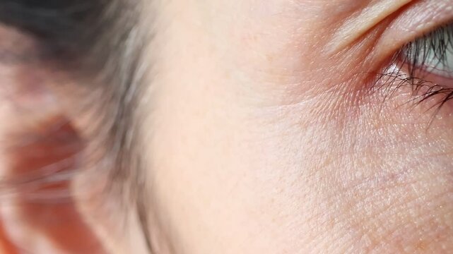 Close upview of woman eyes. Macro shot of middle aged female wrinkles near the eyes. Concept of aging, old skin of wrinkled face of caucasian. Beauty portrait.