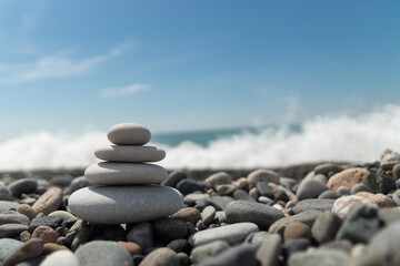 A pyramid of pebbles by the sea, embodying the concept of Zen, meditation and relaxation,a copy space