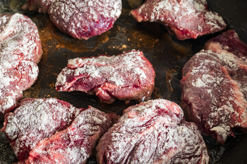 pieces of seasoned beef cheeks sprinkled with flour before frying in oil