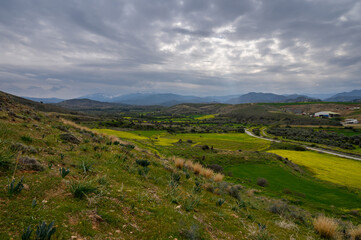 Fototapeta premium Expansive green hills and dramatic sky showcase nature's beauty in a serene landscape