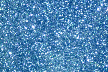 Abstract blue glitter background with sparkling highlights and defocused shimmering light