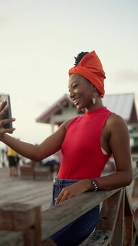 Garifuna woman making a video call on a pier