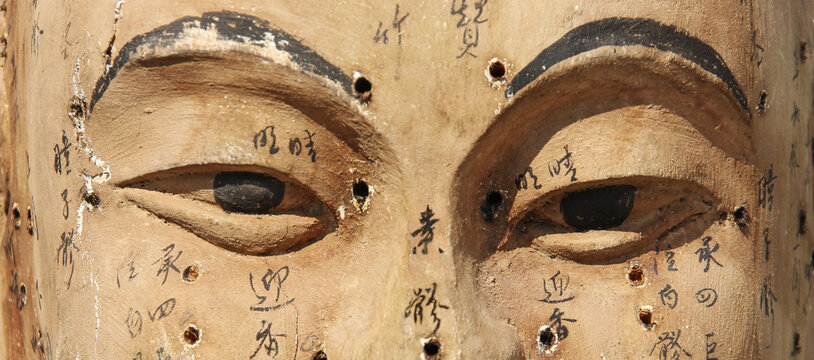 Ancient wooden face showing acupuncture points with their names in Chinese characters - website banner format