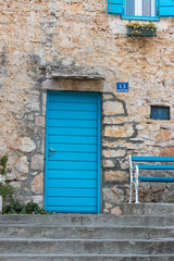 Charming Blue Door on Rustic Stone Wall With Matching Bench