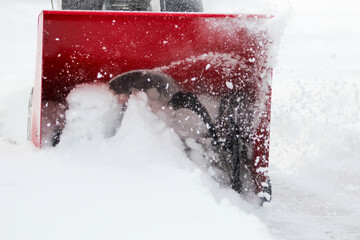 front view of a snowblower in action after a storm with snow churning in impeller blade. winter...