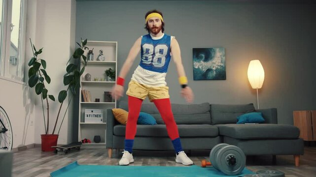 LOS ANGELES, CALIFORNIA, 10 OCTOBER, 2019: Funny stupid-looking reto fitness man dancing enjoying music and warming up on workout in the living room.
