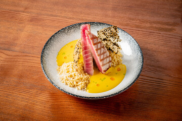 Culinary Artistry Showcases Vibrant Dish With Seared Fish Perched Elegantly on a Bed of Savory Grains and Accented by Rich Sauce in a Cozy Dining Setting.