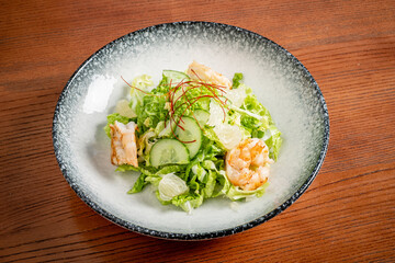 Fresh Salad With Succulent Shrimp, Crisp Lettuce, and Vibrant Cucumber Garnished With a Touch of Red Threads During a Sunny Afternoon at a Cozy Eatery.