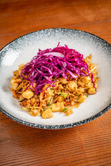 Delicious Stir-Fried Noodles With Vibrant Red Cabbage Served on an Elegant Plate, Inviting Diners to Savor the Flavors of an Asian-inspired Dish Prepared in a Cozy Kitchen.