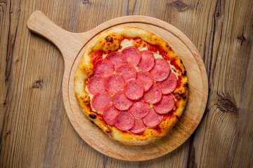 Savory Pepperoni Pizza Served on a Rustic Wooden Board, Showcasing a Deliciously Baked Crust Topped With Generous Slices of Pepperoni and Melted Cheese.