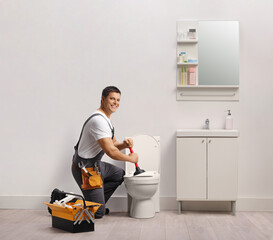 Plumber unclogging a toilet in a bathroom