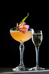 Delightful Cocktail Masterpiece Adorned With a Vibrant Flower, Inviting Relaxation at a Chic Bar During a Cozy Evening Gathering.