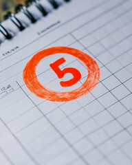 Fototapeta premium Number 5 circled in red on a calendar page
