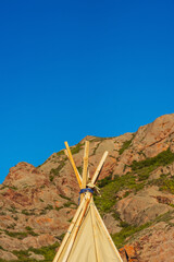 wooden tent in the field of Almaty. wigwam made of wooden sticks and cotton fabric © Yashkin Ilya