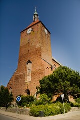 Gothic Church of Our Lady of Częstochowa in Darłowo, Poland, bathed in August sunlight, showcasing its rich history. © Grzegorz