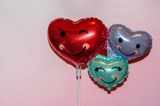 Tres globos en forma de corazón con una sonrisa alegre. Soy bien "cute" y "kawaii". El fondo el reosado. Son perfectos para un regalo.