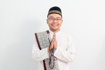 Asian Muslim man wearing white clothes doing praying hand pose during Ramadan Eid Al Fitr and eid...