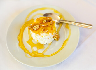 Portion of delicious cottage cheese with walnuts and honey
