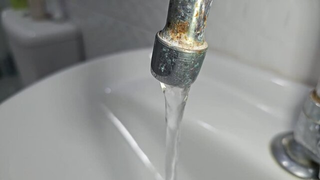 Torneira do banheiro, aberta: &aacute;gua correndo sem parar, economia e sustentabilidade. 