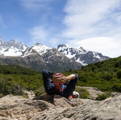Fototapeta premium A man lying down with his hands behind his head looking at the snowy mountains