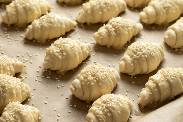 Homemade crescent rolls dough with sesame seeds in a baking pan.