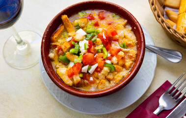 Cojondongo, typical summer dish from Extremadura with chopped tomatoes, pepper and eggs, day-old bread and dressing of garlic, olive oil and water, traditionally served cold in earthenware bowl