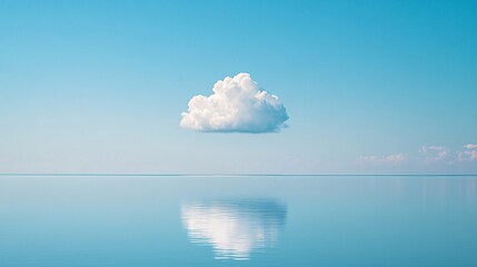 Tranquil image of a single white cloud mirrored in calm blue waters under a vast sky