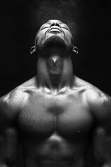Strong man exhaling steam while enjoying a moment of tranquility in a dark setting