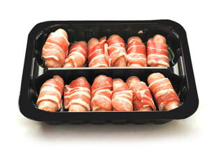 Pigs in blanket in a black plastic tray on white background. Party pork food . Tasty appetizers. Simple meal.