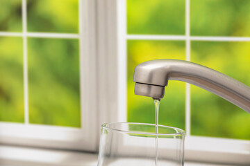 Low water pressure flowing from kitchen faucet. Water conservation, shortage and safe drinking...
