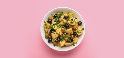 Bowl of tasty potato salad on pink background, top view
