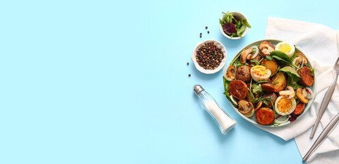 Plate of tasty potato salad and spices on light blue background with space for text, top view