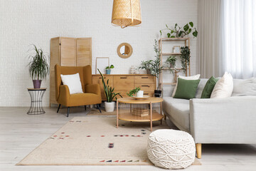 Obraz premium Interior of living room with mirror, grey sofa and armchair