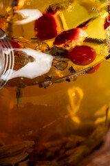 red rosehip fruits and hot green tea in a transparent teapot