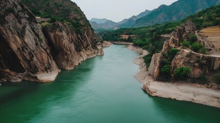 Scenic River Winding Through Rocky Mountain Landscape Under Cloudy Sky : Generative AI