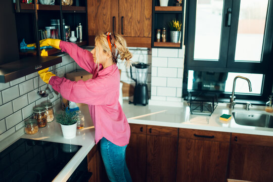 Woman cleaning modern kitchen with careful attention