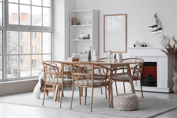 Light interior of room with dining table, fireplace and winter decor