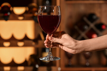 Female hand with glass of red wine in restaurant