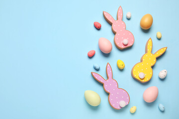 Wooden bunnies with Easter eggs on blue background