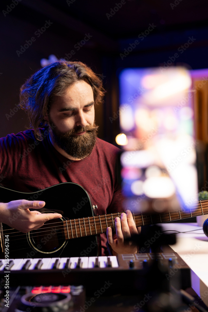 Poster professional singer teaching guitar lessons online on social media channel, recording himself playin