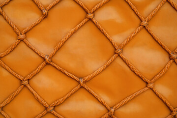 Fototapeta premium Textured orange fabric with knotted rope pattern designed for stylish upholstery