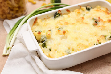 Baking dish with tasty pasta, broccoli and green onion, closeup