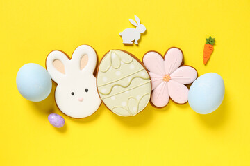 Composition with eggs, Easter cookies in shape of flower, egg and bunny on yellow background