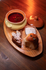 Restaurant dish borscht, delicious bread with bacon, sour cream, bun. A delicious photo for a menu, culinary website, or an advertisement for catering establishments.