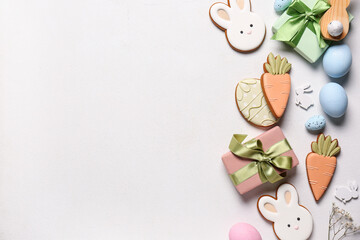 Composition with eggs, gift box and different Easter cookies on white background