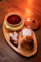 Restaurant dish borscht, delicious bread with bacon, sour cream, bun. A delicious photo for a menu, culinary website, or an advertisement for catering establishments.