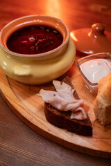 Restaurant dish borscht, delicious bread with bacon, sour cream, bun. A delicious photo for a menu, culinary website, or an advertisement for catering establishments.
