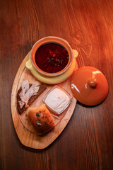 Restaurant dish borscht, delicious bread with bacon, sour cream, bun. A delicious photo for a menu, culinary website, or an advertisement for catering establishments.