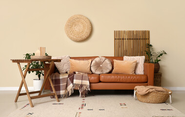 Comfortable sofa with plaid and table in interior of room