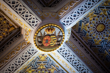 Sintra, Portugal - 09 27 2017: Pena Palace ceiling with royal crest and intricate decorative elements.